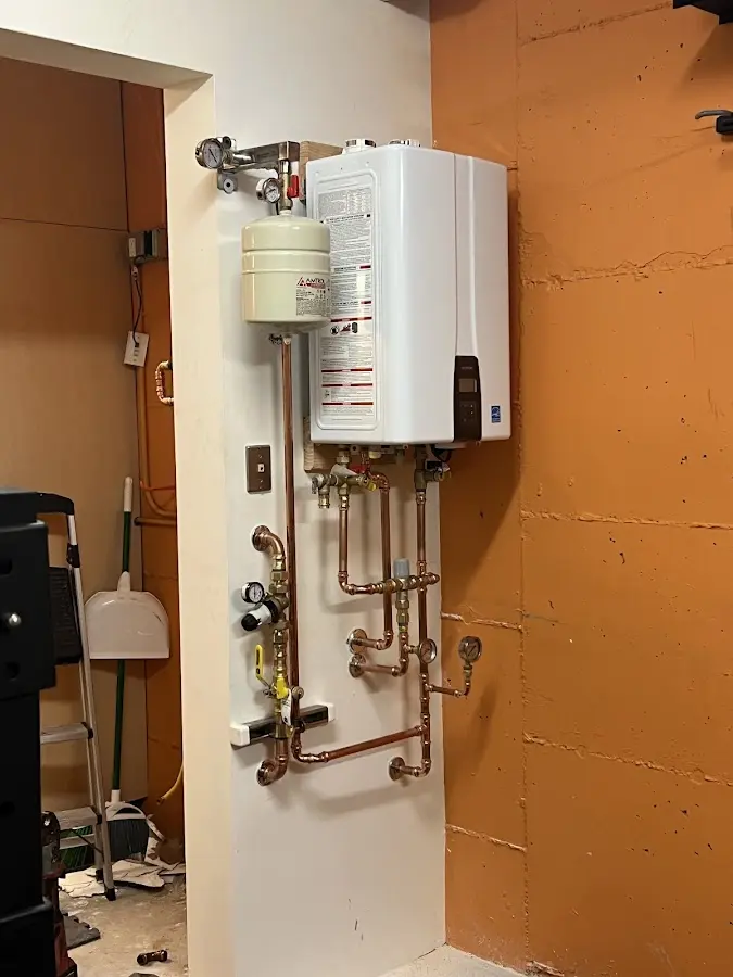 Plumbing technician inspecting water heater connections in Loves Park